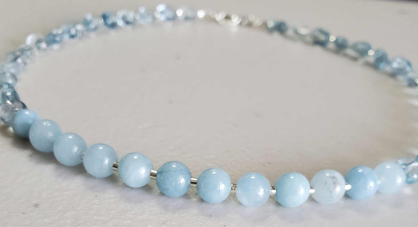 Aquamarine gemstone jewelry set featuring a necklace and bracelet with soft blue beads and a lobster claw clasp