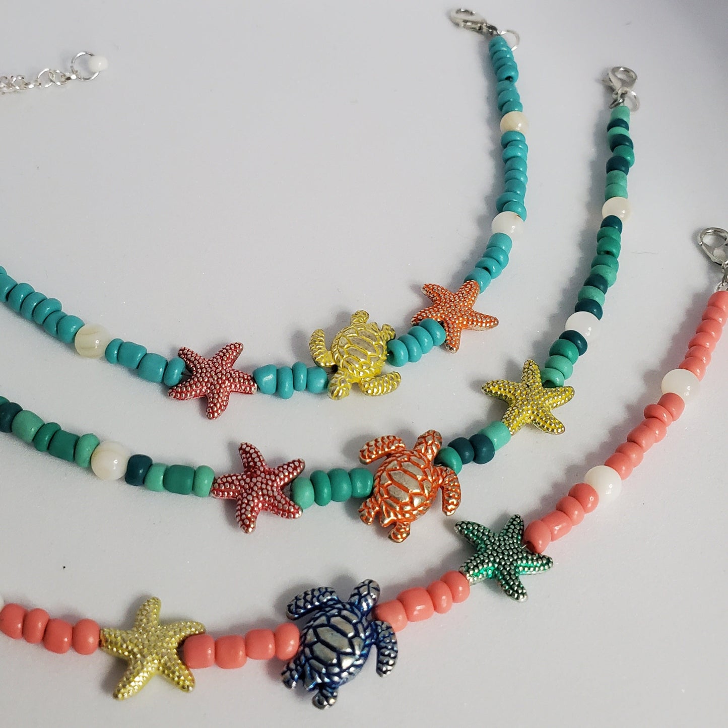 Anklets with starfish and turtle charms on a white background
