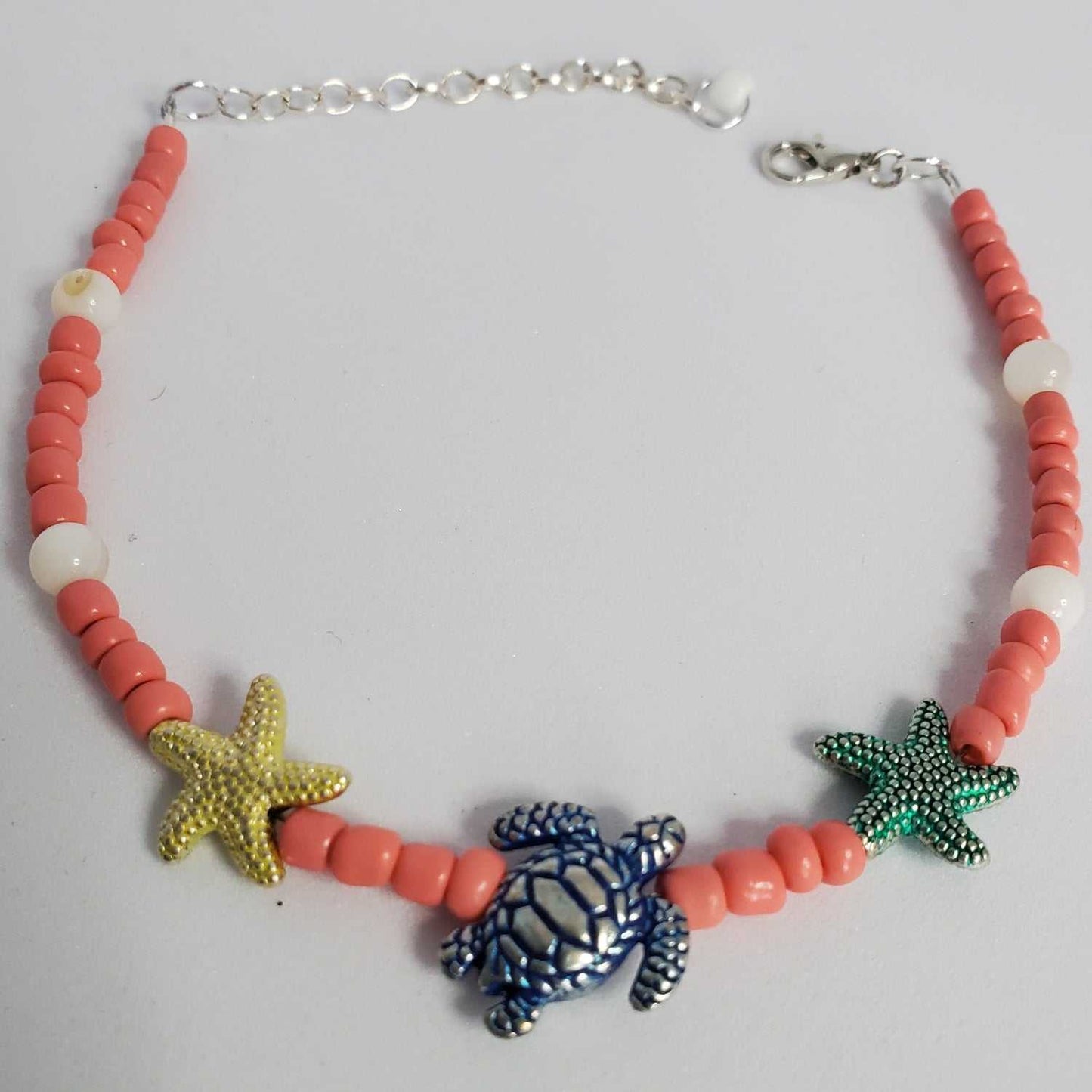 Beach anklet with pewter turtle, starfish charms, coral beads, and adjustable clasp