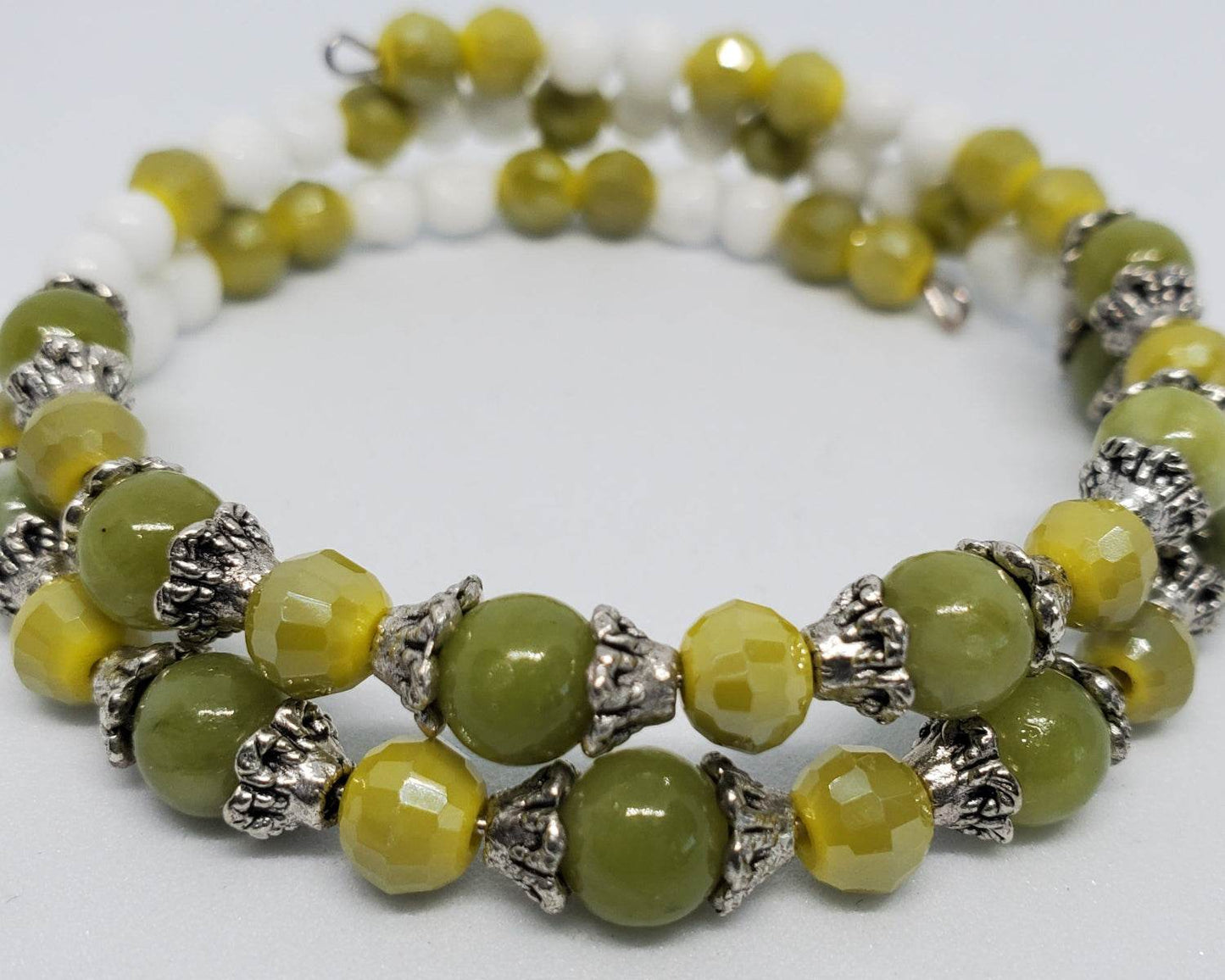 Handcrafted gemstone bracelet with green peridot and yellow Japanese glass beads on a silver-plated memory wire cuff