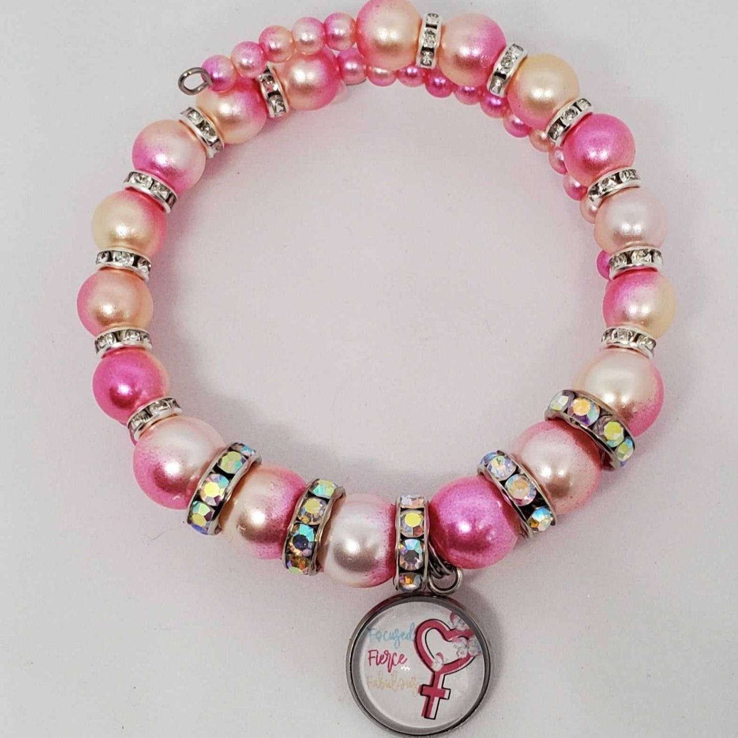 Pink and cream ombre pearl charm bracelet with rhinestone spacers and a female symbol charm on a flexible memory wire band