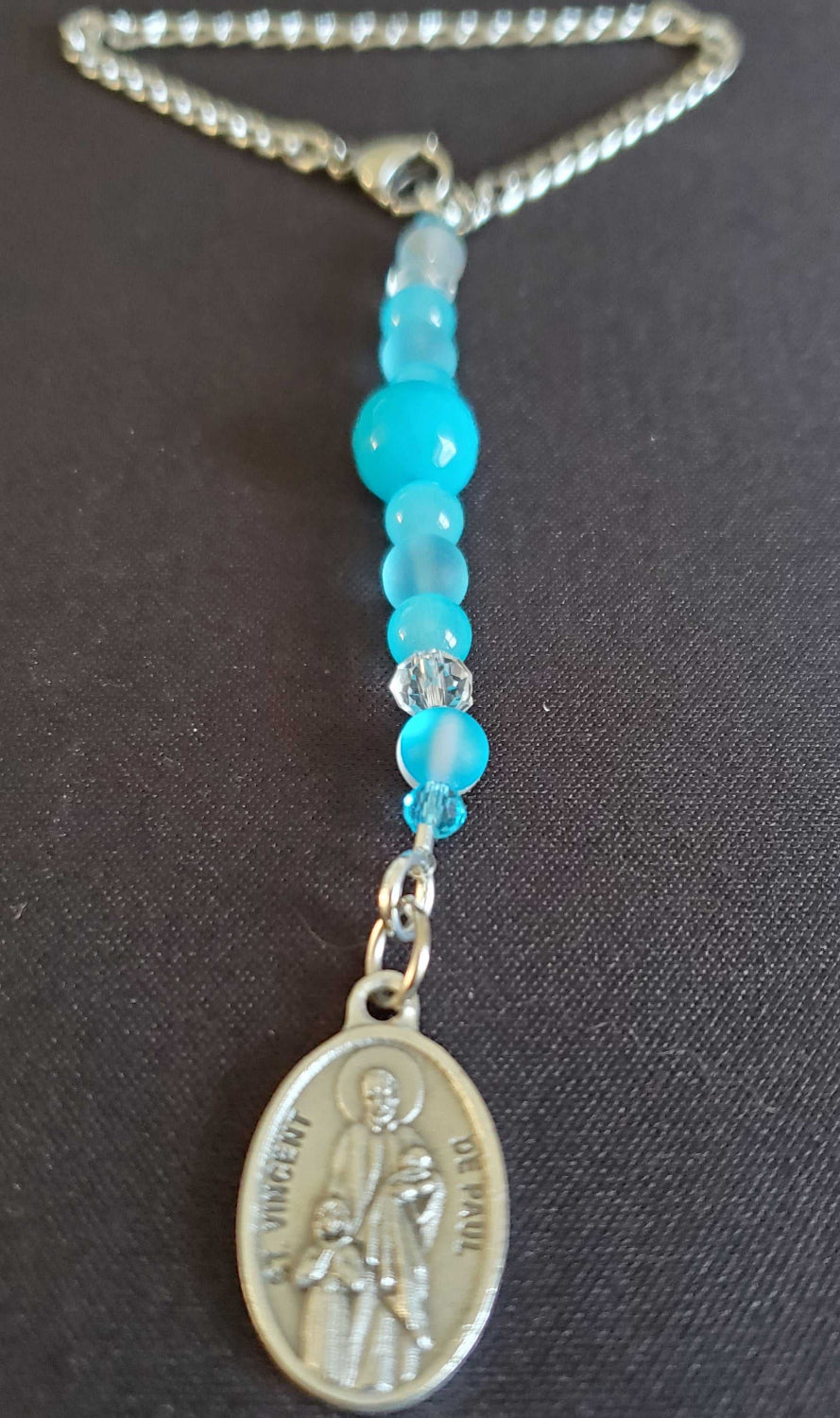 Rearview mirror car charm featuring St. Vincent de Paul medallion with blue beads and glass crystal inlay.