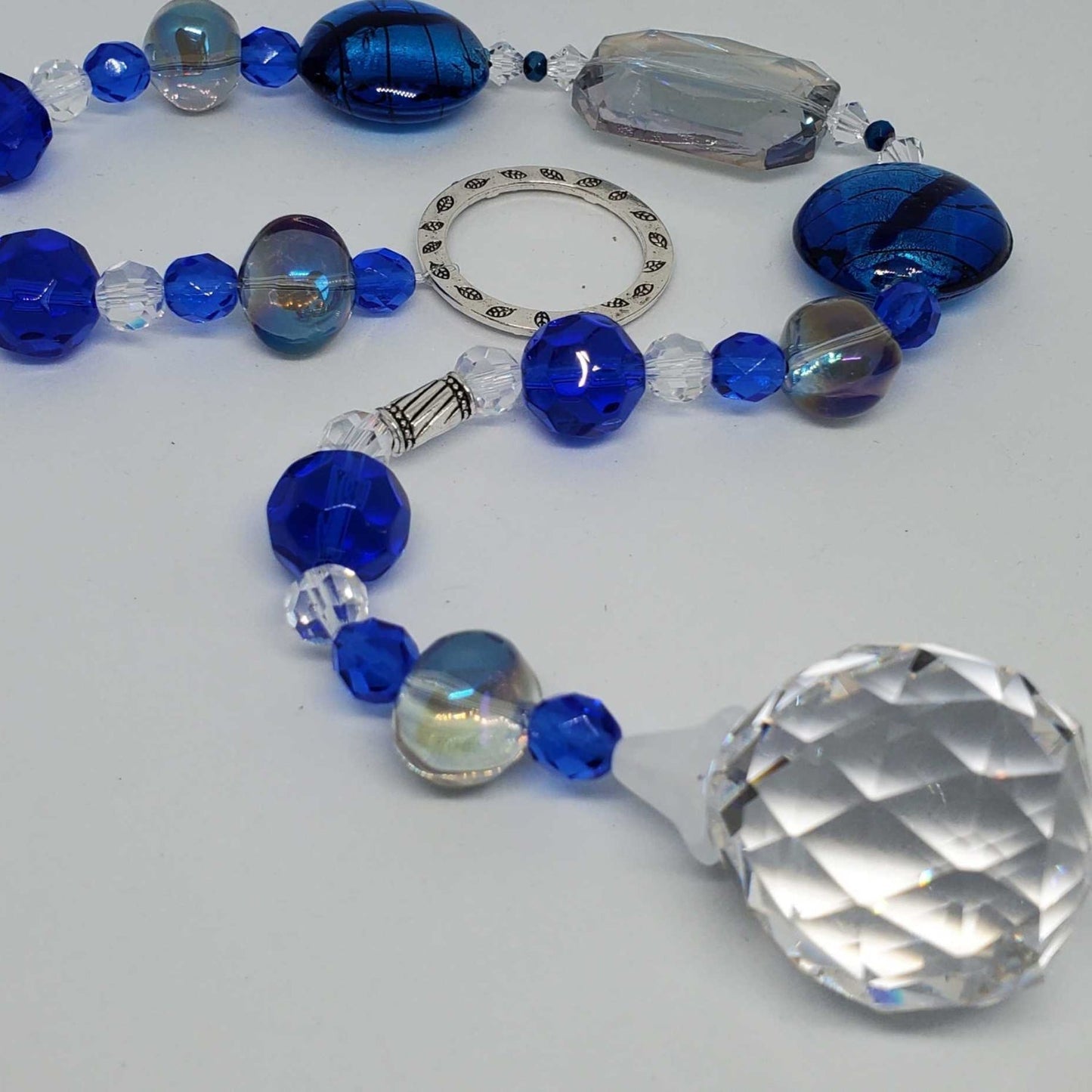 Handcrafted cobalt blue crystal suncatcher with 30mm prism hanging in sunny window