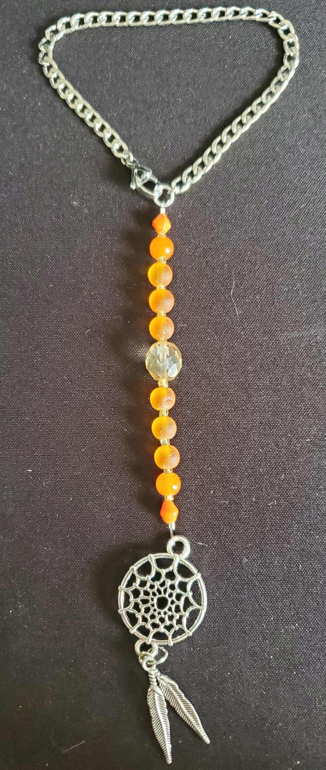 Rearview mirror car charm dreamcatcher with feathers, crystals, and glass beads hanging inside vehicle