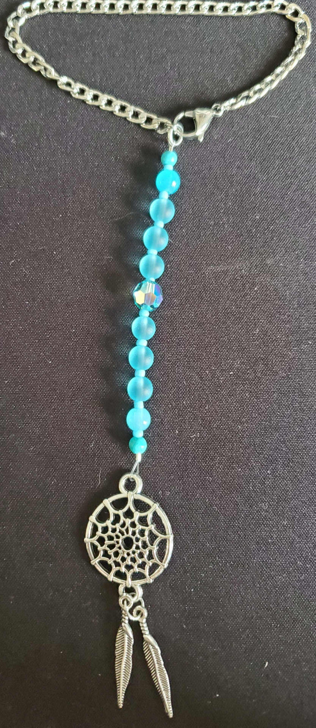 Rearview mirror car charm dreamcatcher with pewter, feathers, crystals, and beads hanging in car interior