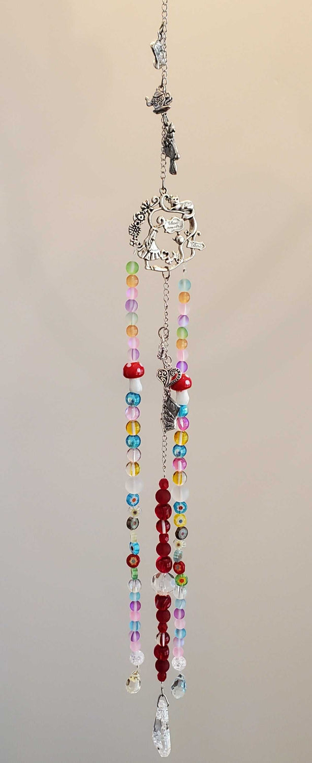 Colorful Crystal Suncatcher with pewter charms and glass beads inspired by Wonderland hanging in sunlight