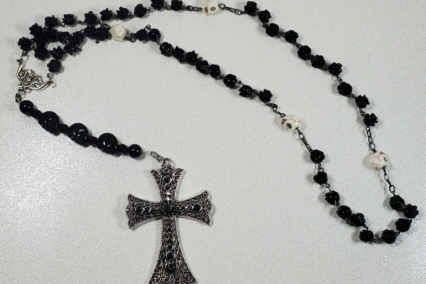 Gothic gemstone necklace featuring Onyx rose beads, Howlite skull beads, and a detailed pewter cross pendant.