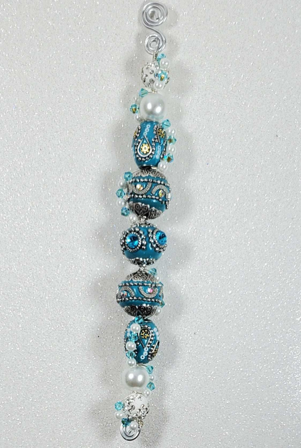Vintage fashion-inspired handcrafted beaded ornament with intricate blue, white, and pearl details.
