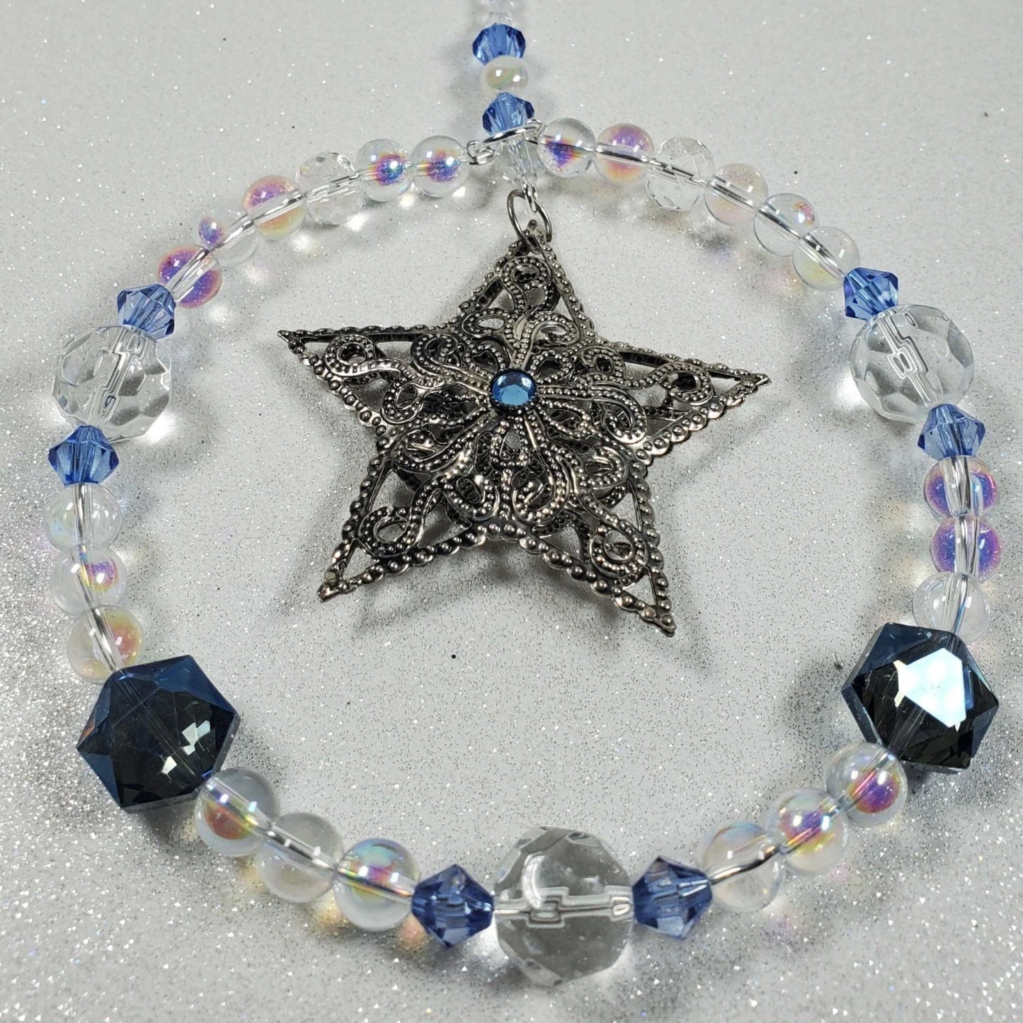 Handcrafted filigree star Holiday Ornament with pewter design and clear blue glass beads, 6.5 inches long, perfect for festive decoration.
