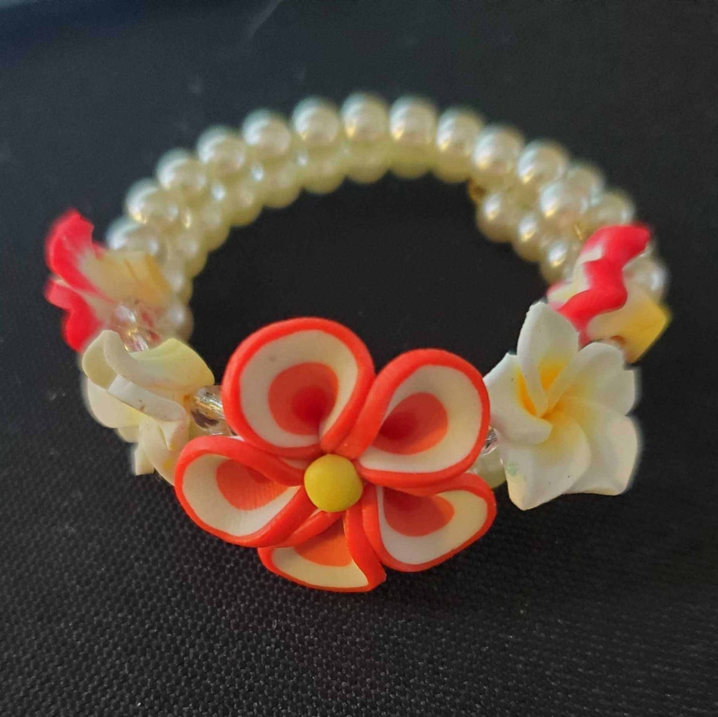 Colorful floral jewelry child’s bracelet with polymer flower beads, acrylic pearls, and pink crystals on flexible memory wire.