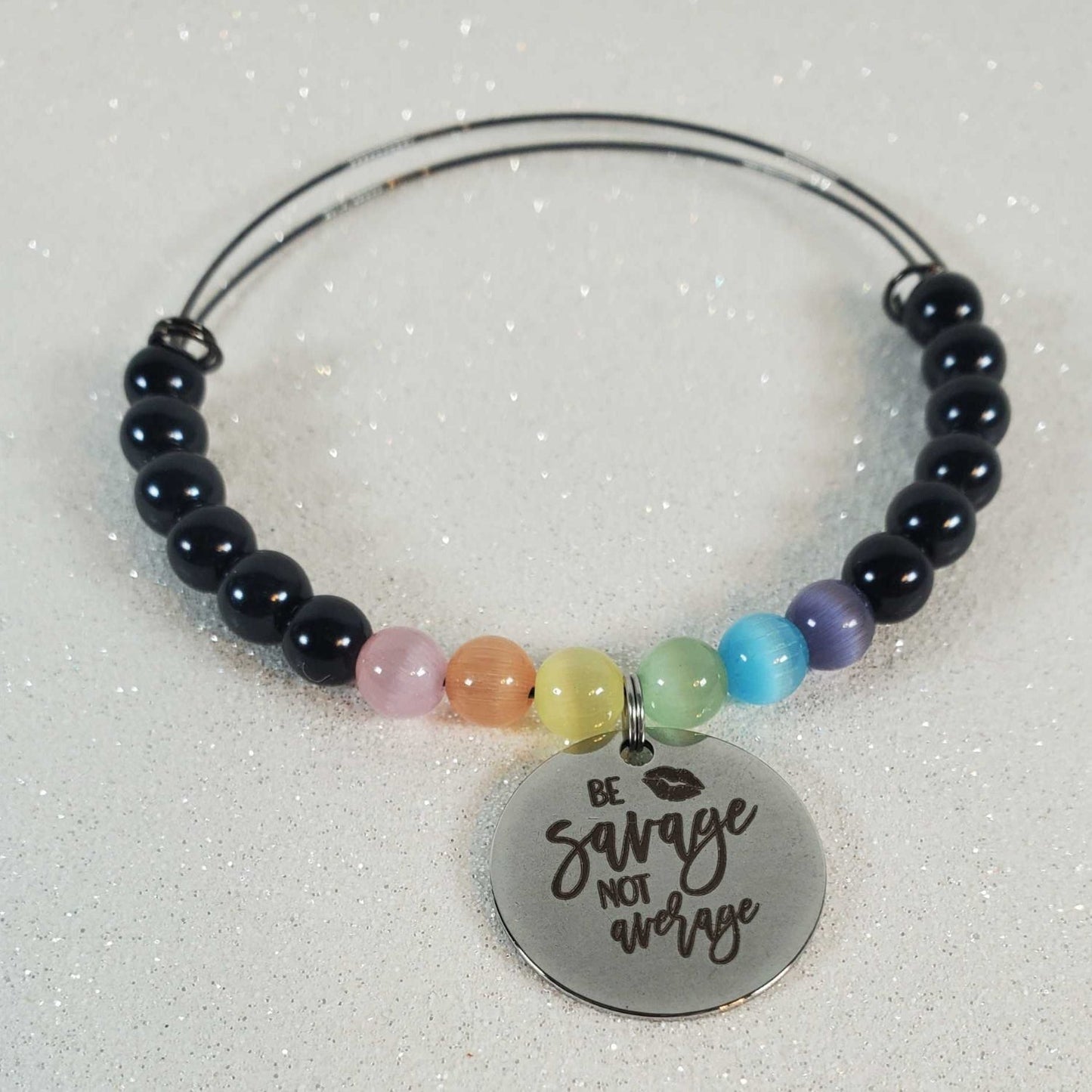 Gemstone Bracelet with black Cat's Eye beads, colorful glass accents, and a "Be Savage not Average" pewter charm on a flexible memory wire band.
