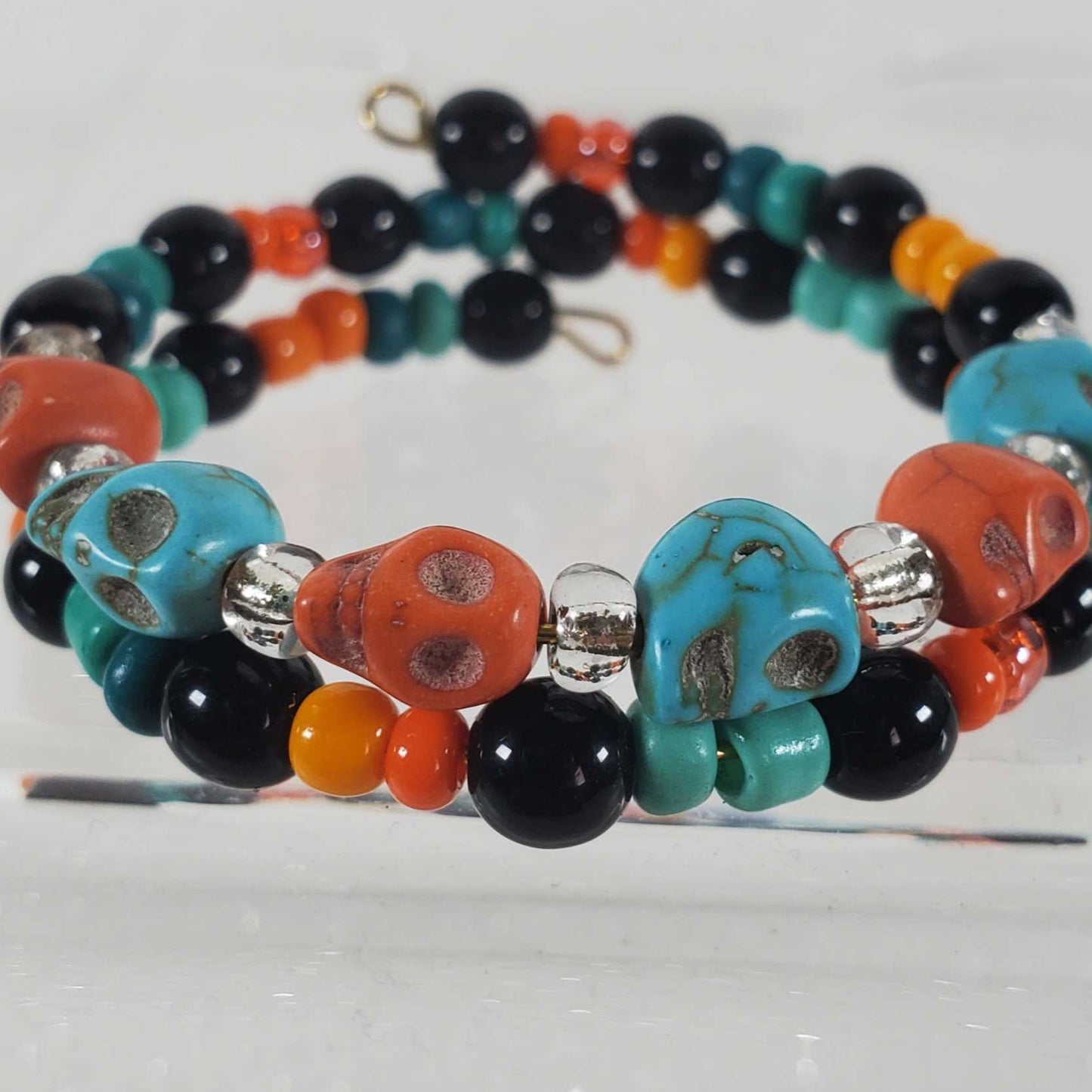 Children's skull bracelet with turquoise and orange skull beads, black and colorful accents, adjustable memory wire band for Halloween or gothic style