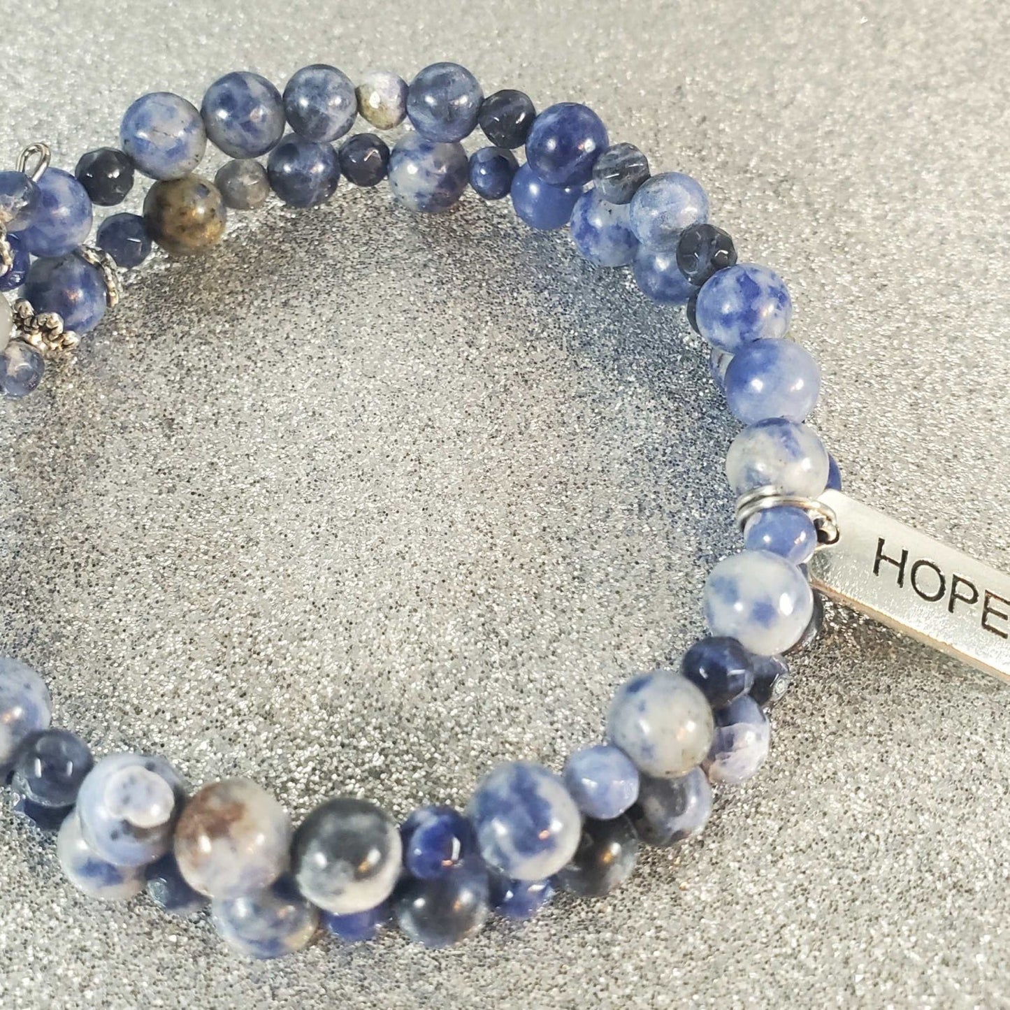 Blue sodalite gemstone bracelet with pewter "Hope" charm on memory wire cuff