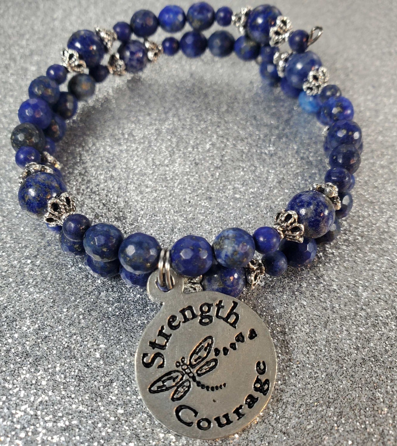 Blue gemstone bracelet with "Strength & Courage" pewter charm and silver accents on adjustable memory wire.