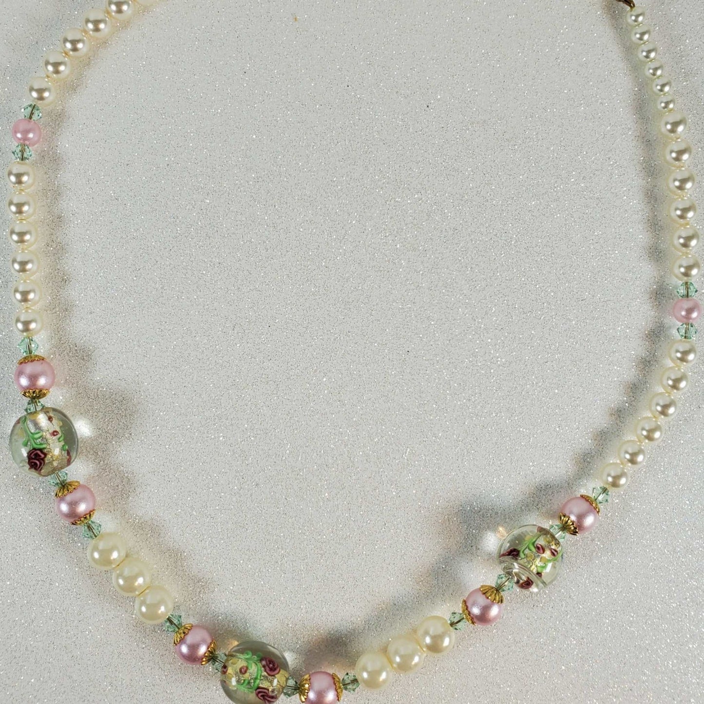 Necklace with pearls and colorful beads on a light gray background