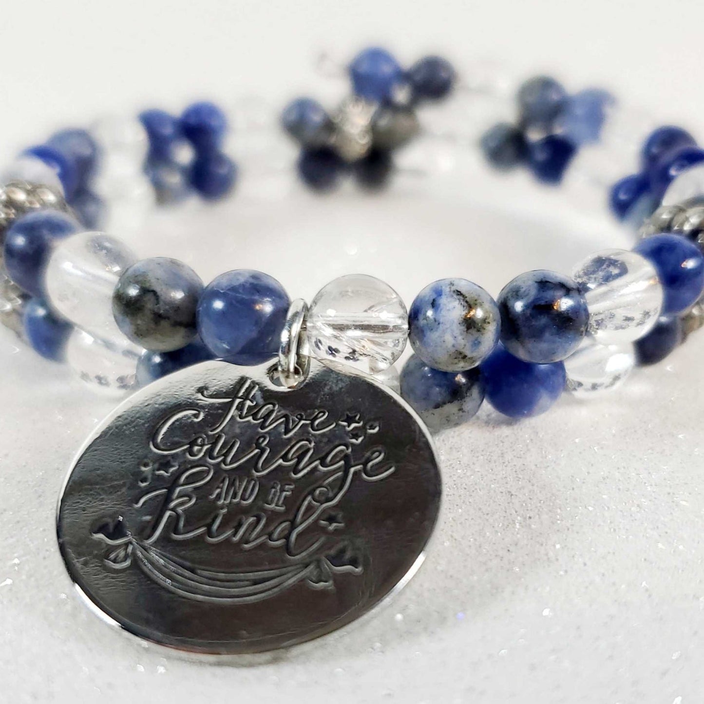 Inspirational gemstone bracelet with sodalite and clear quartz beads featuring a "Have Courage Be Kind" engraved charm and pewter accents