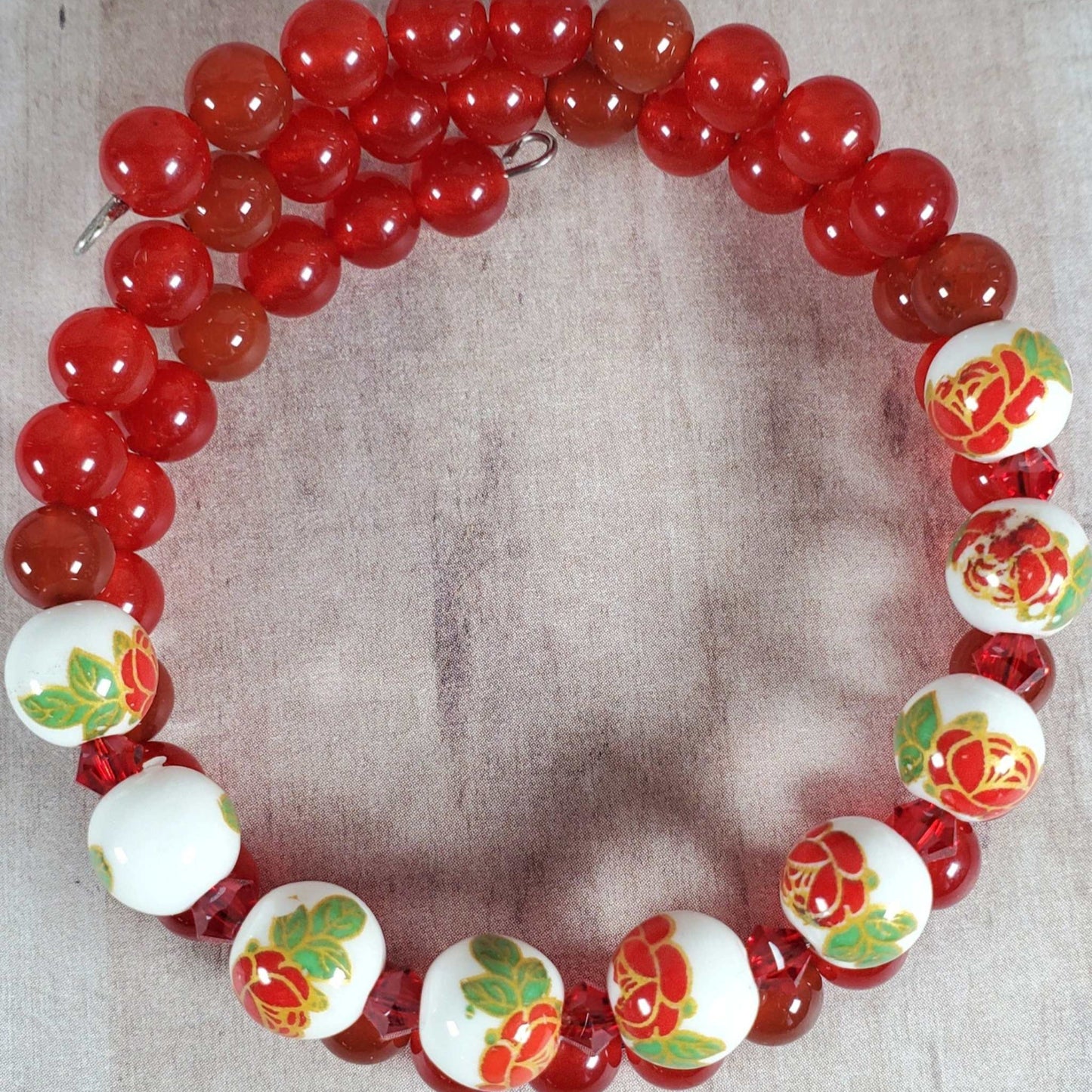 Floral Bracelet with red gemstone beads and white porcelain floral beads on memory wire