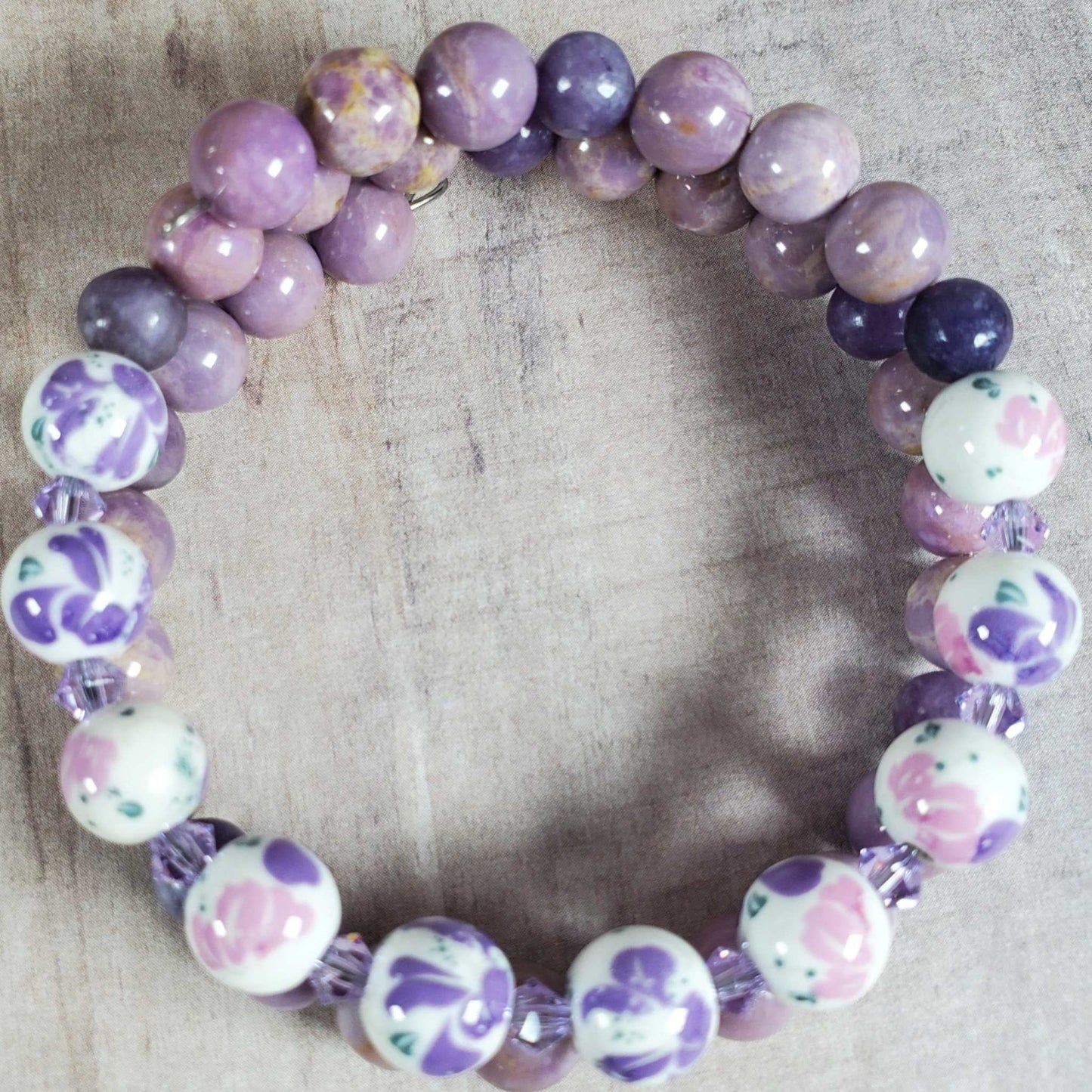 Floral bracelet with purple gemstone beads and white porcelain floral beads on flexible memory wire