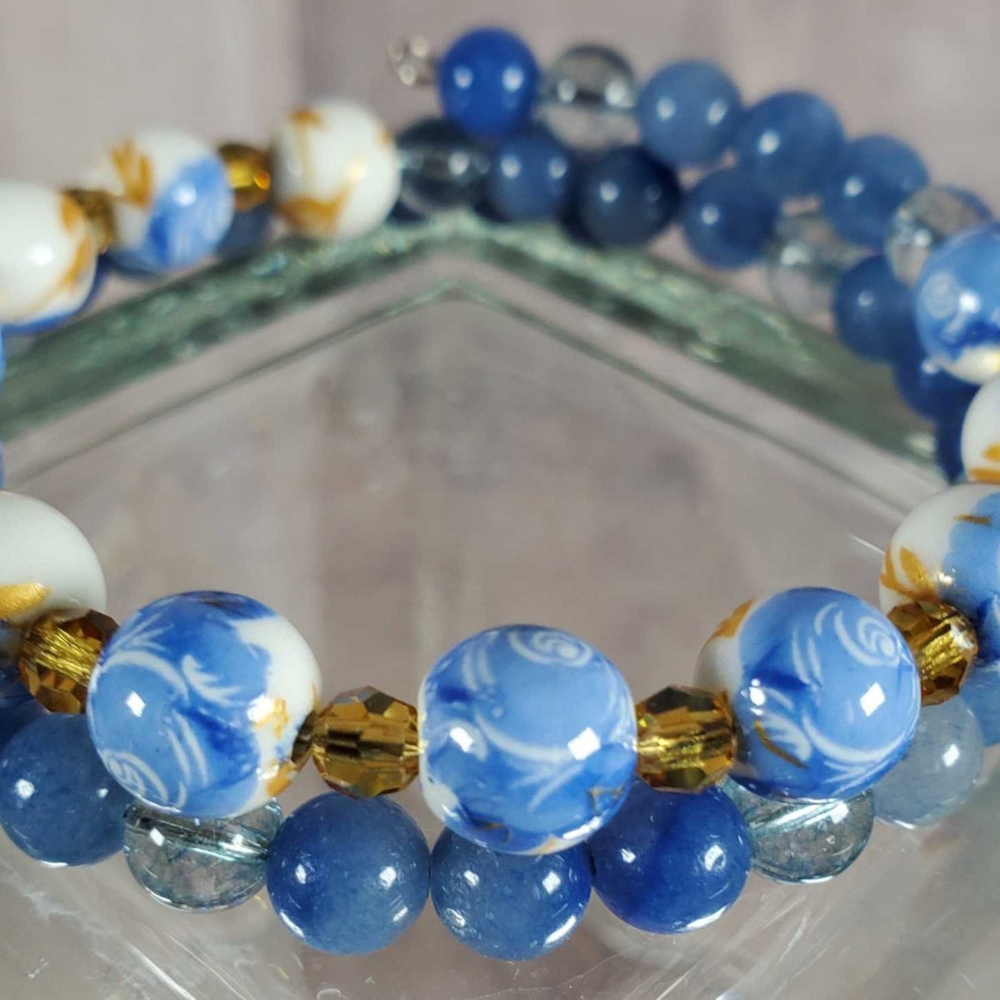 Blue and white floral porcelain gemstone bracelet on reflective surface