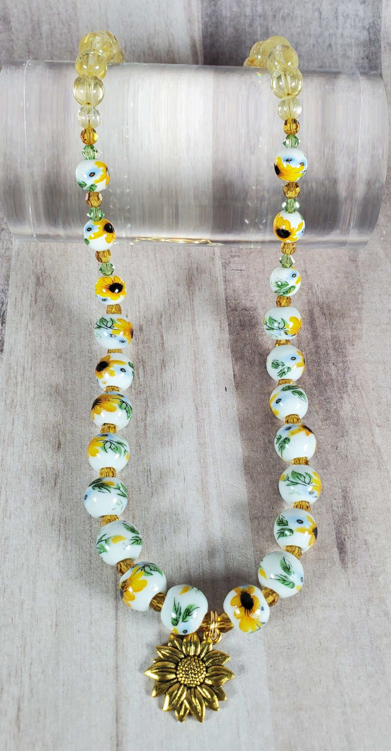 Floral necklace with porcelain sunflower beads, citrine gemstones, and brass sunflower charm.