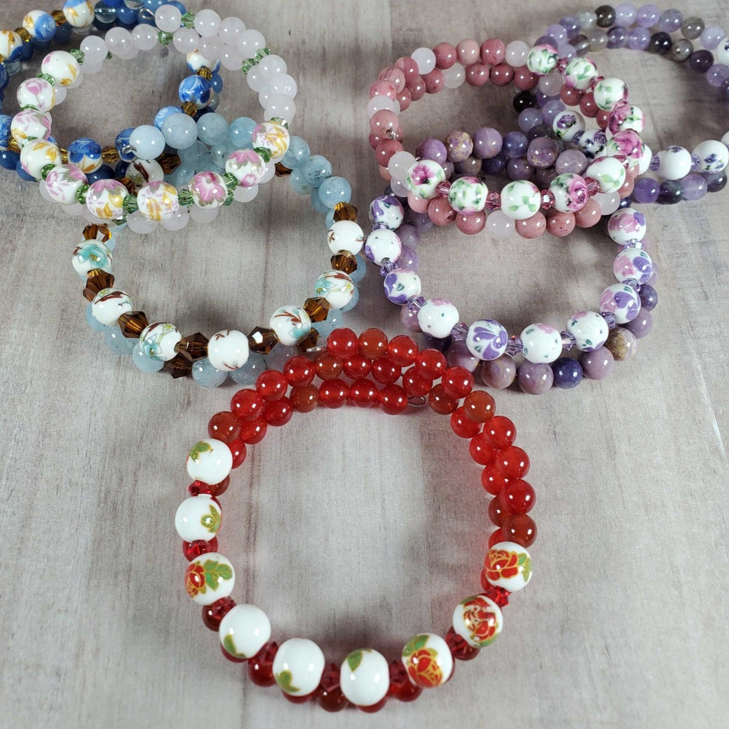 Collection of colorful floral bracelets with gemstone and porcelain floral beads on memory wire