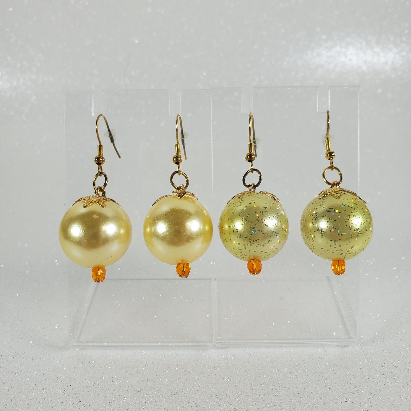 Set of gold and pearl earrings on a clear background