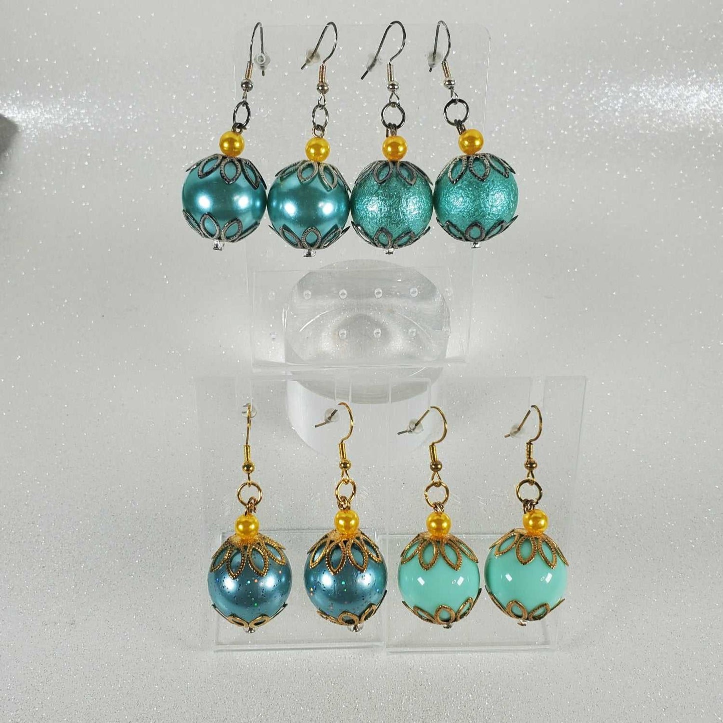 Turquoise beaded earrings with gold accents on a white background