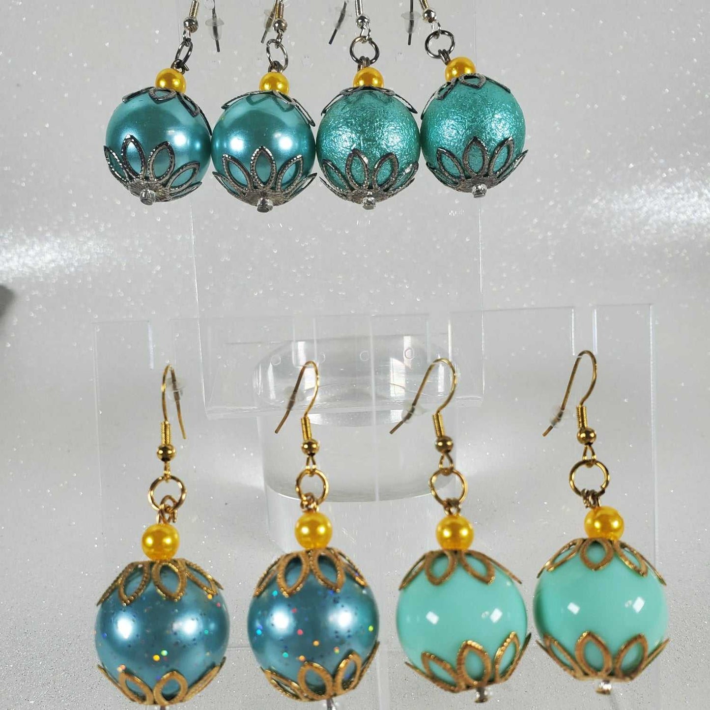 Turquoise and gold beaded earrings on a white background
