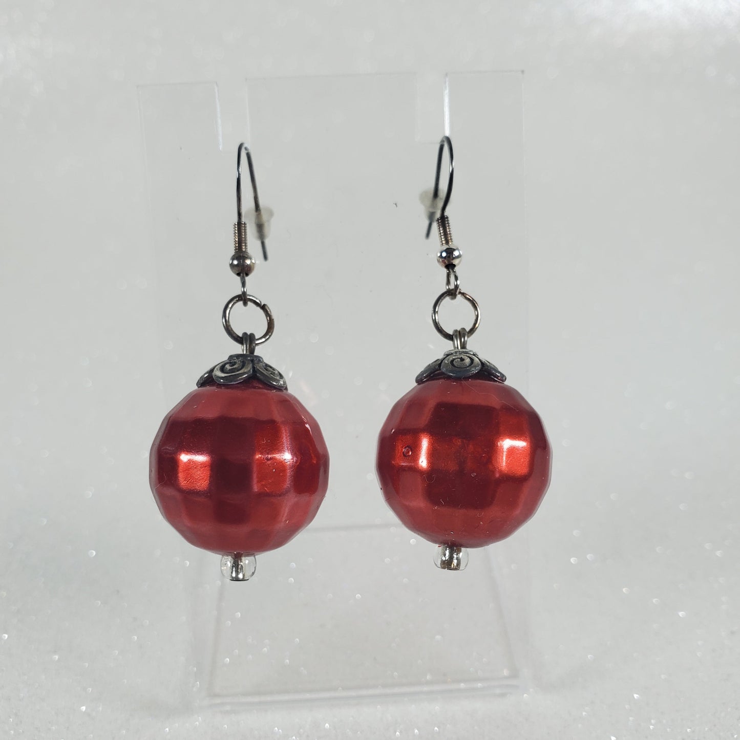 Red spherical earrings on a clear background