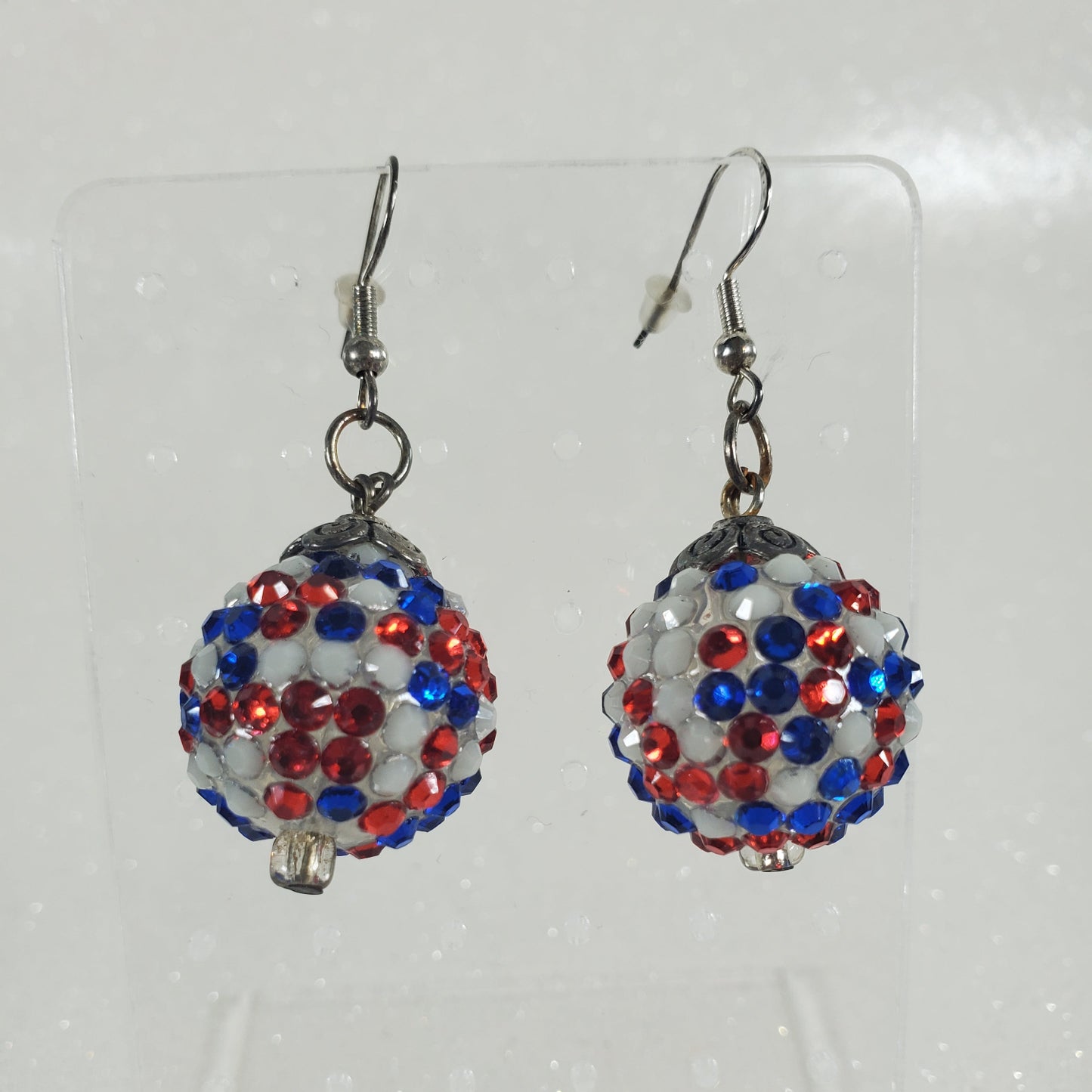 Pair of beaded earrings with red, white, and blue rhinestones on a clear card.