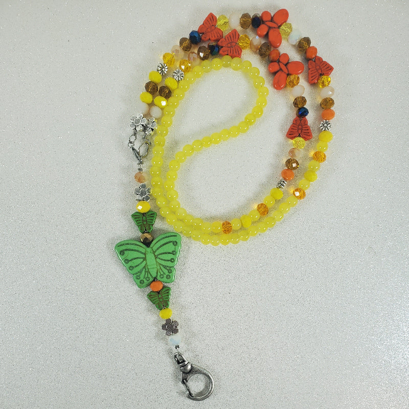 Beaded lanyard with butterfly charm on a white background