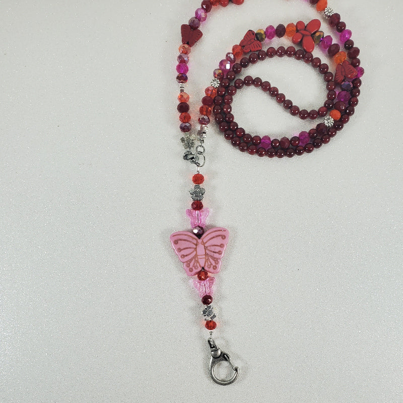 Beaded lanyard with a butterfly charm on a light gray background