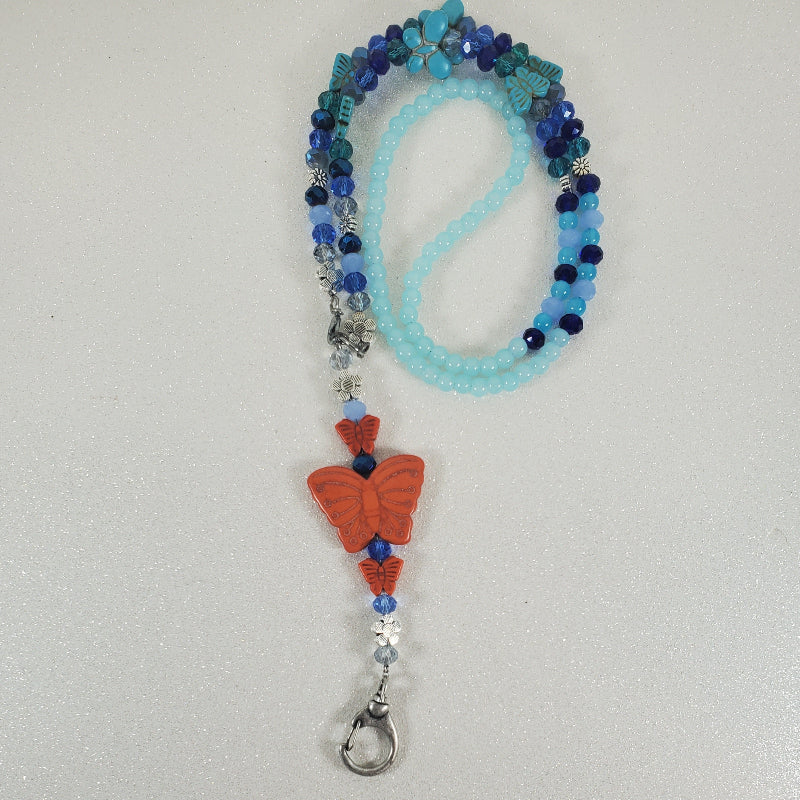 Beaded lanyard with a butterfly charm on a light gray background