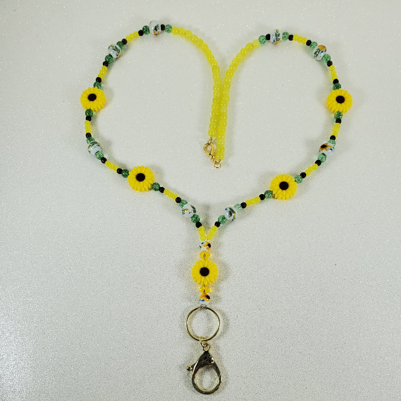 Yellow lanyard with sunflower designs on a white background