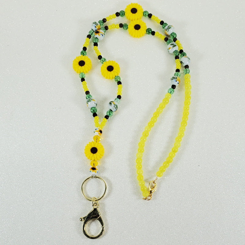 Yellow lanyard with floral designs on a white background