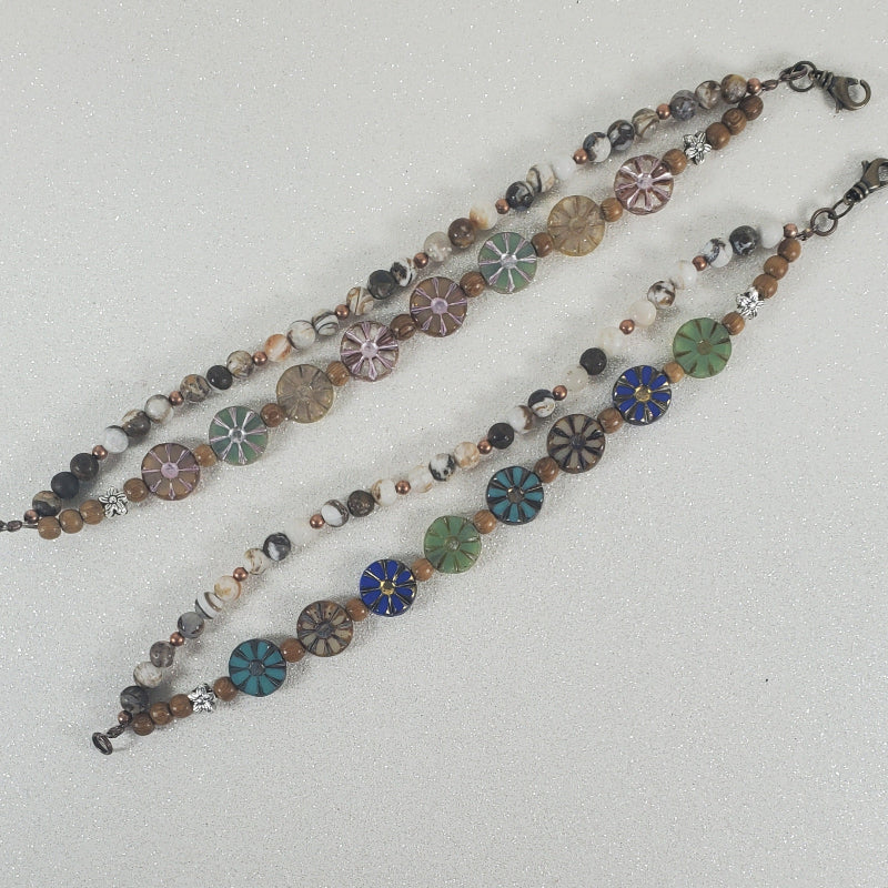Two beaded floral bracelets with circular beads on a light gray background