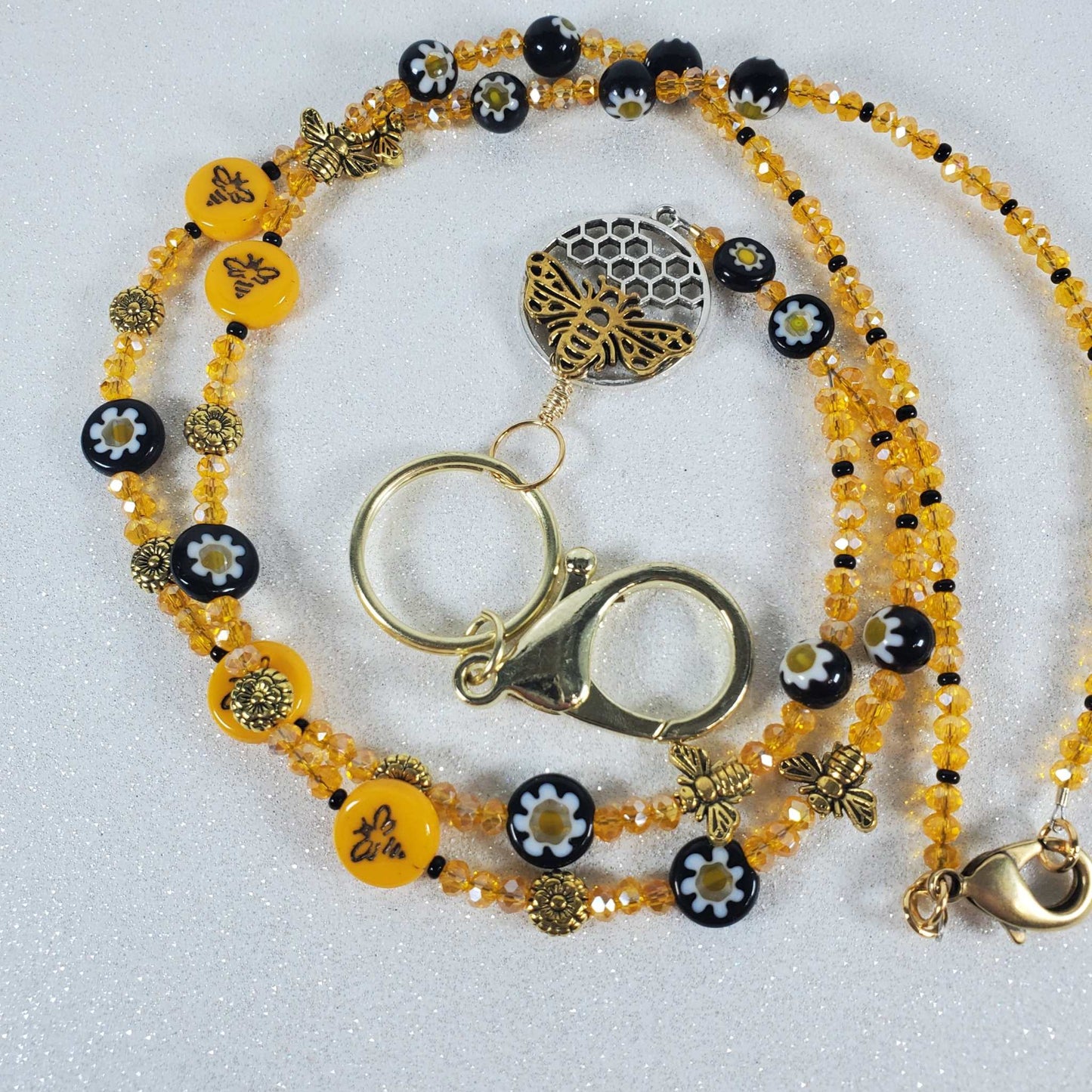 Bee-themed lanyard with Czech glass, Austrian crystals, brass accents, Millefiori flower beads, and pewter honeycomb pendant with bee accents