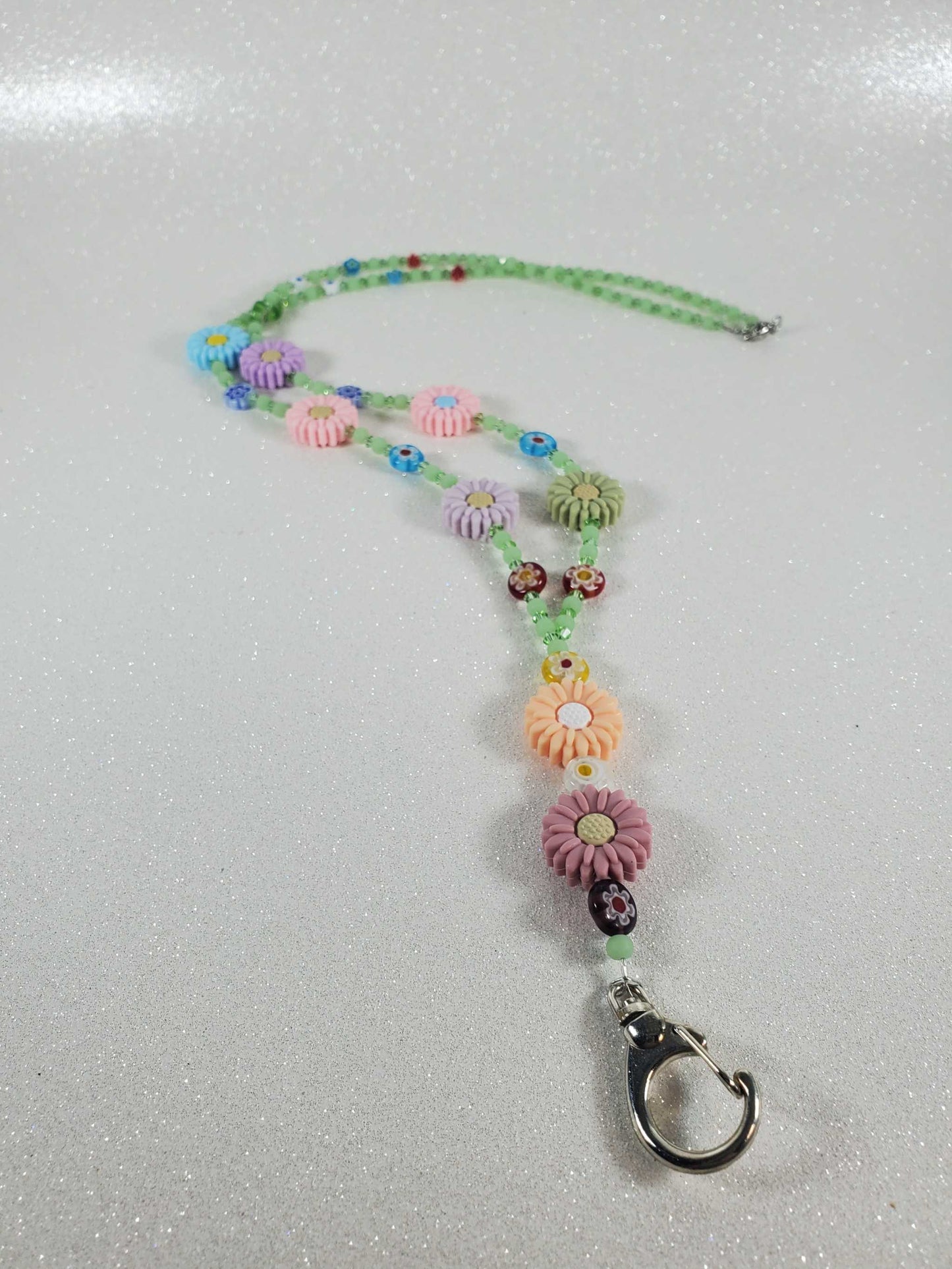 Colorful Daisy Daze lanyard with polymer daisies, Millefiori beads, green glass, and Austrian crystals, 30-inch handmade design with keychain clasp.