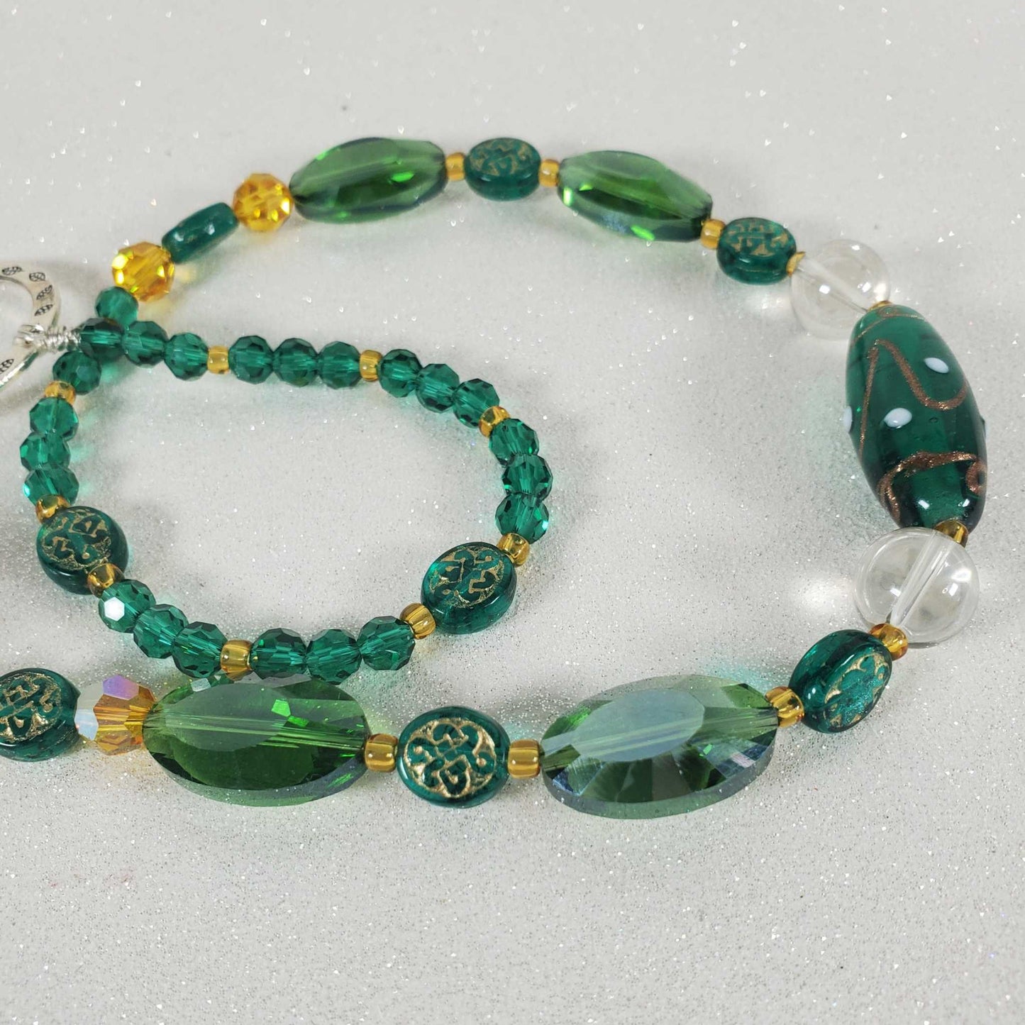 Celtic green crystal suncatcher with emerald beads and drop prisms on white background