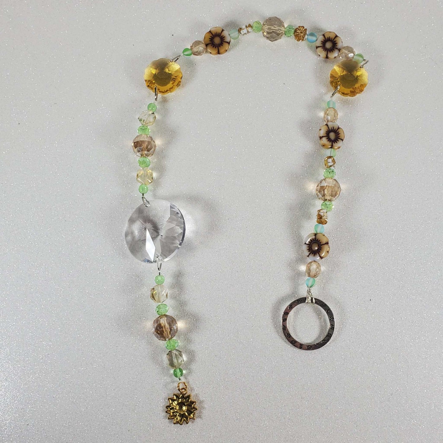 Sunflower crystal suncatcher with clear prism, topaz flower prisms, white glass flowers, green beads, and brass sunflower charm