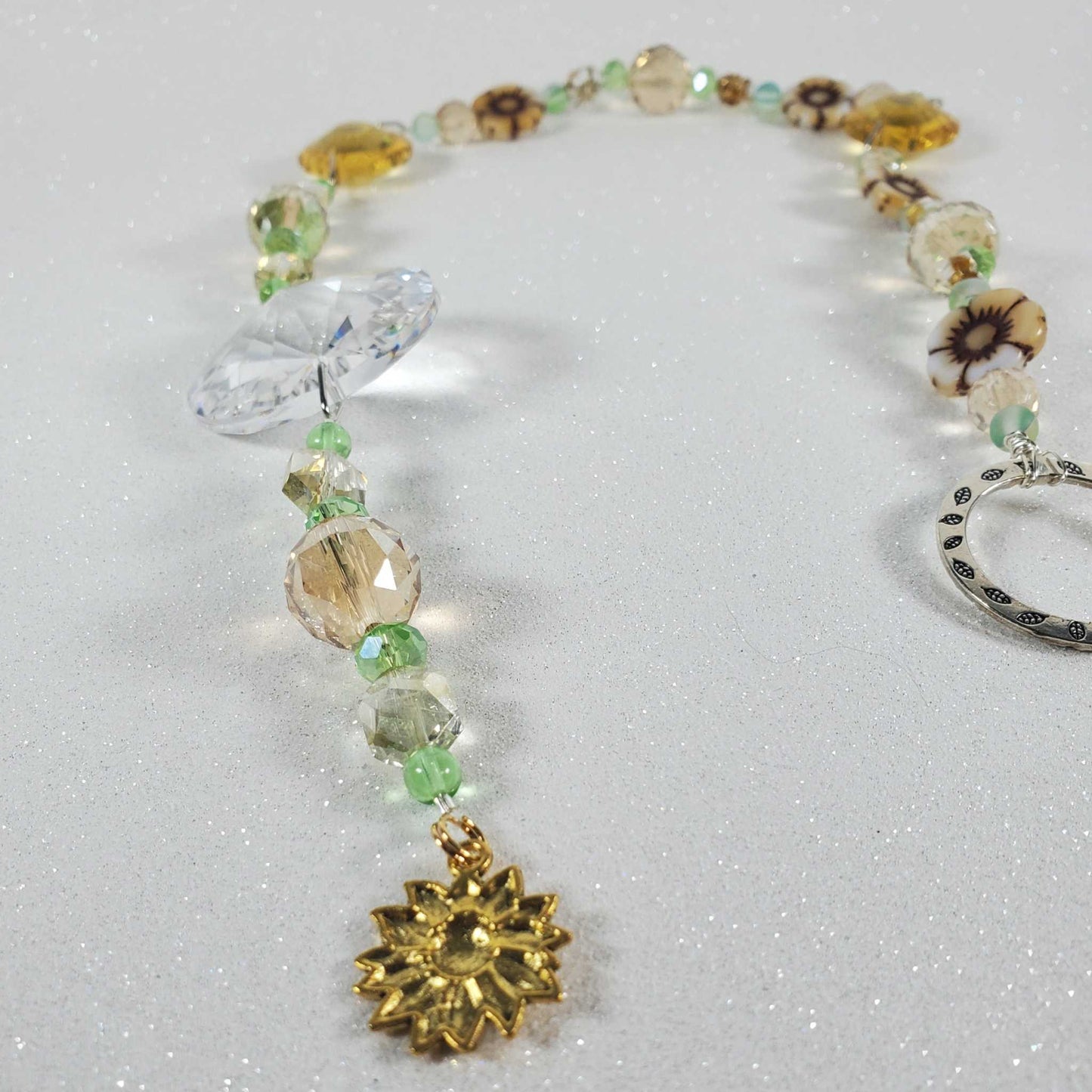 Sunflower crystal suncatcher with clear prism, topaz flower beads, green glass beads, and brass sunflower charm