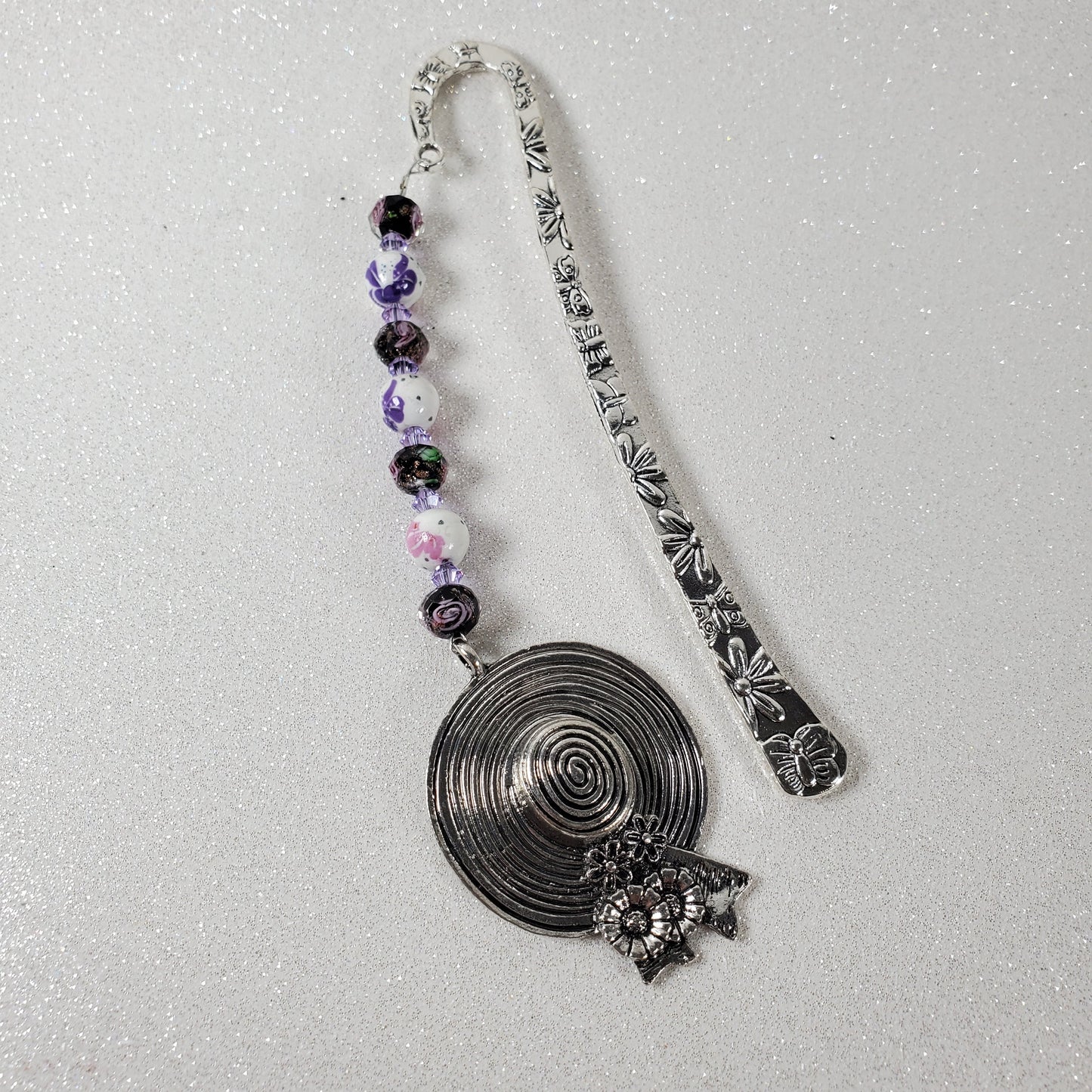 Decorative bookmark with purple beads on a white background