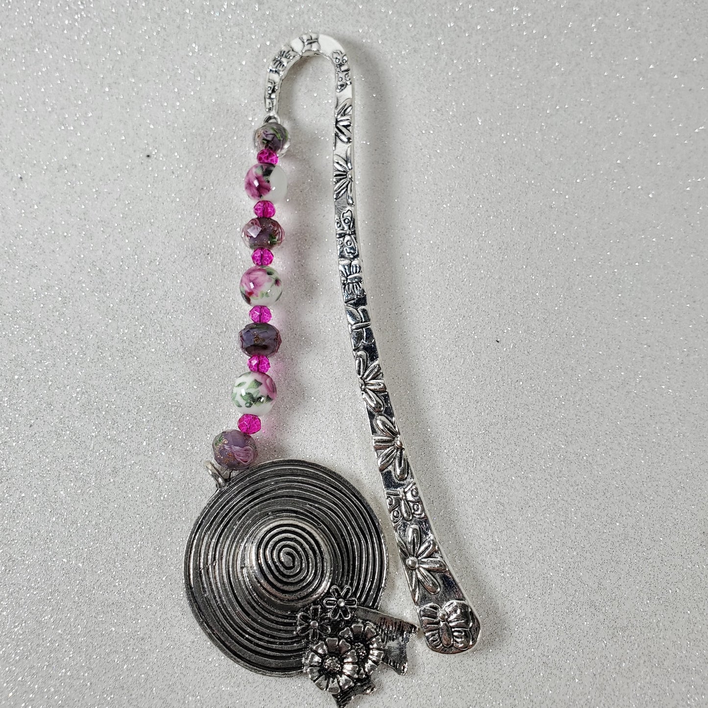 Decorative metal bookmark with beads on a gray background