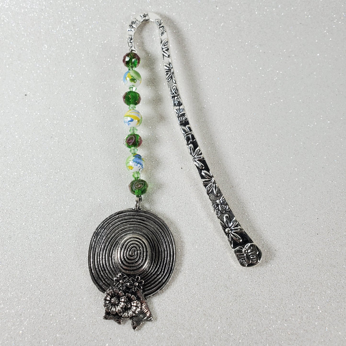 Decorative metal bookmark with beads on a white background