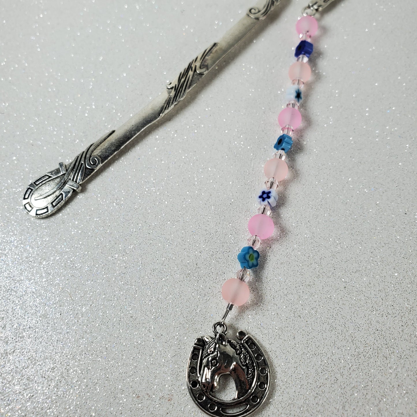 Decorative beaded pink bookmark on a light gray background