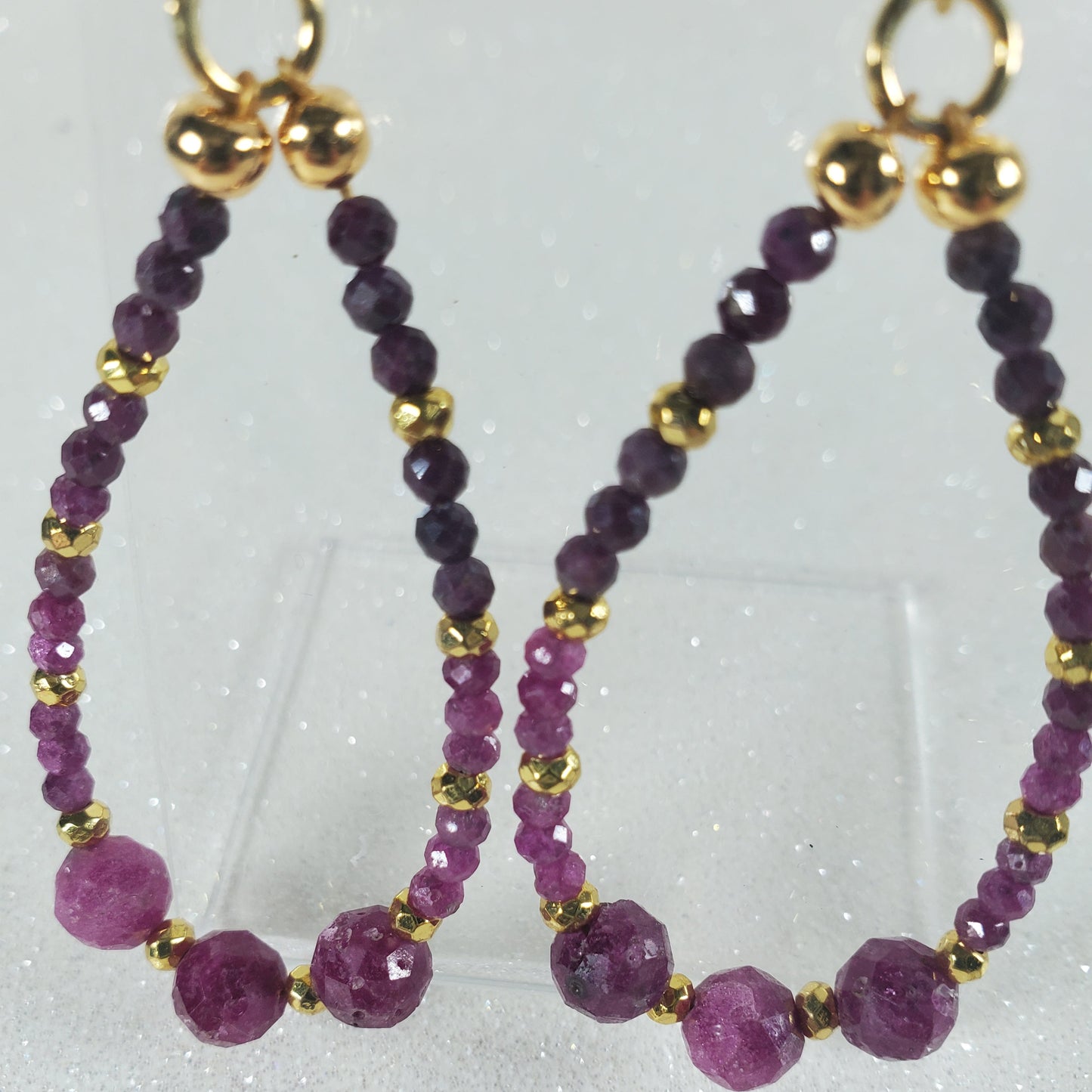 Ruby beaded earrings with gold accents on a white background