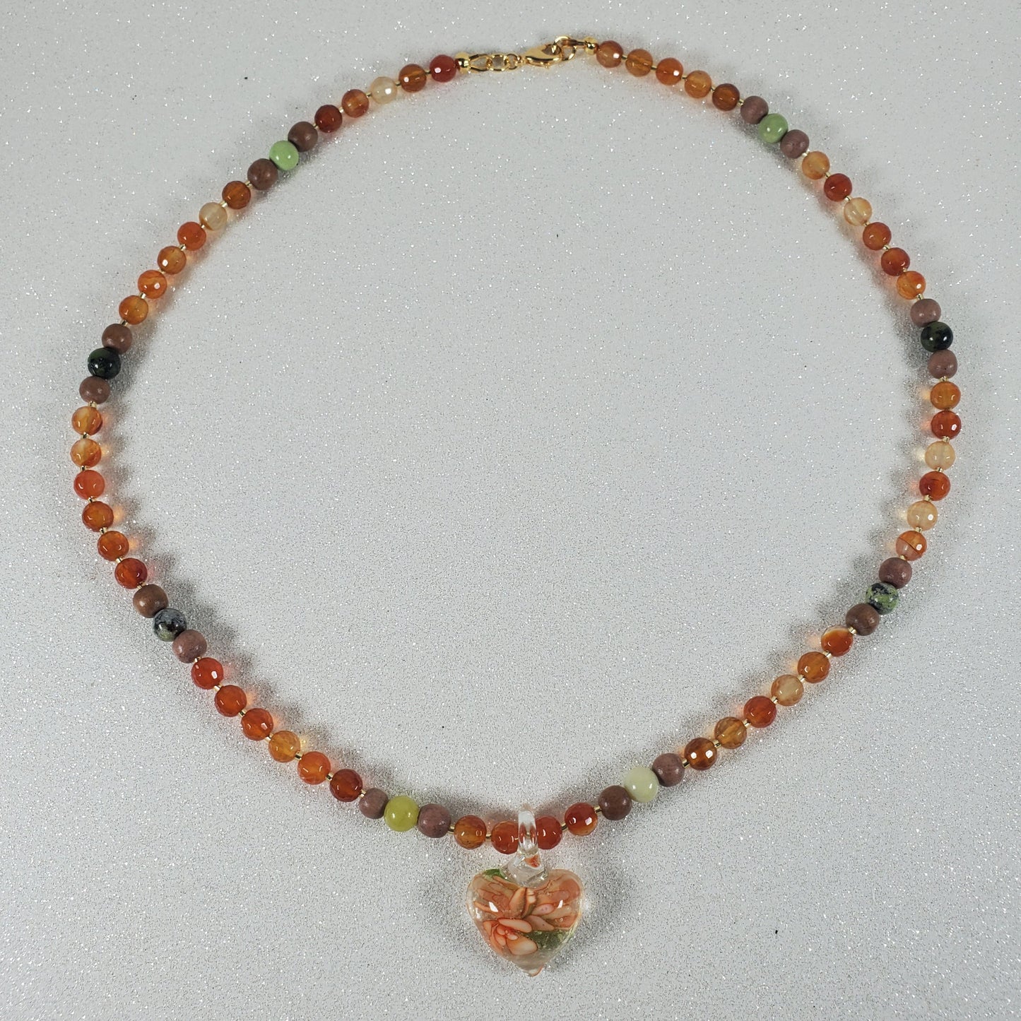 Beaded necklace with a floral pendant on a light gray background