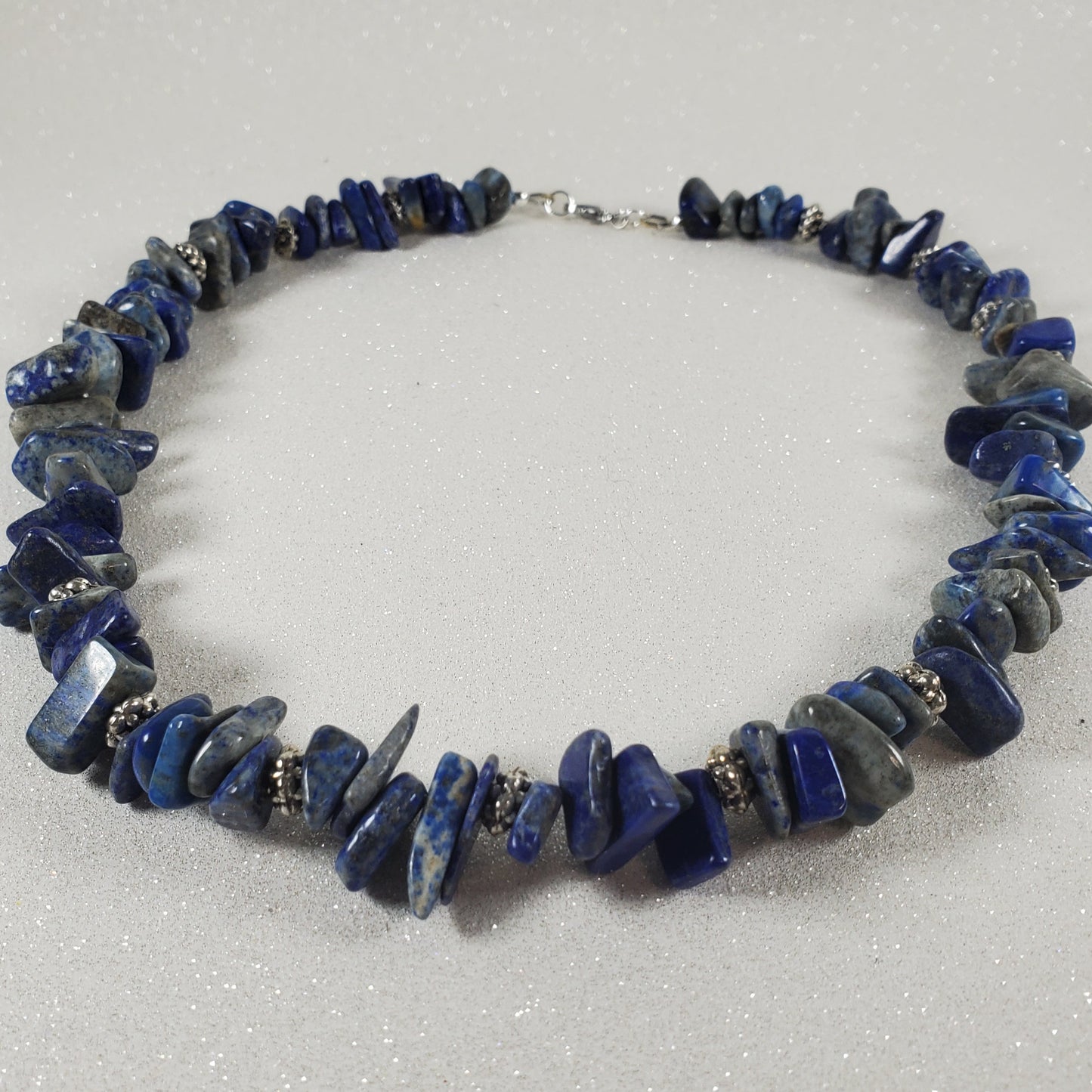Necklace with blue stone chips on a white background