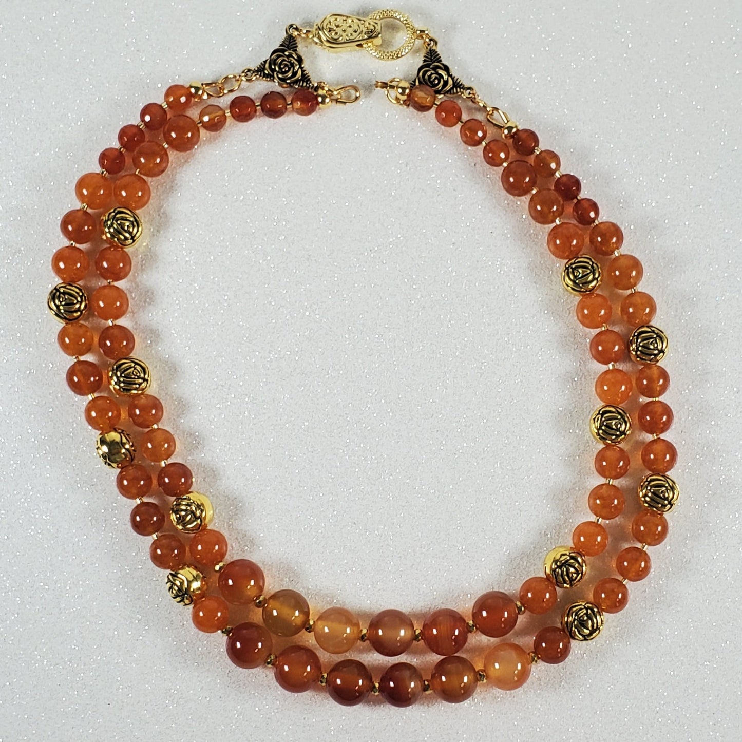 Necklace with orange and gold beads on a white surface