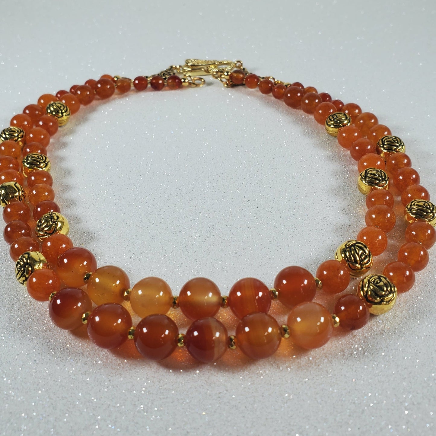 Gemstone necklace featuring vibrant carnelian beads and vintage brass accents with rose details